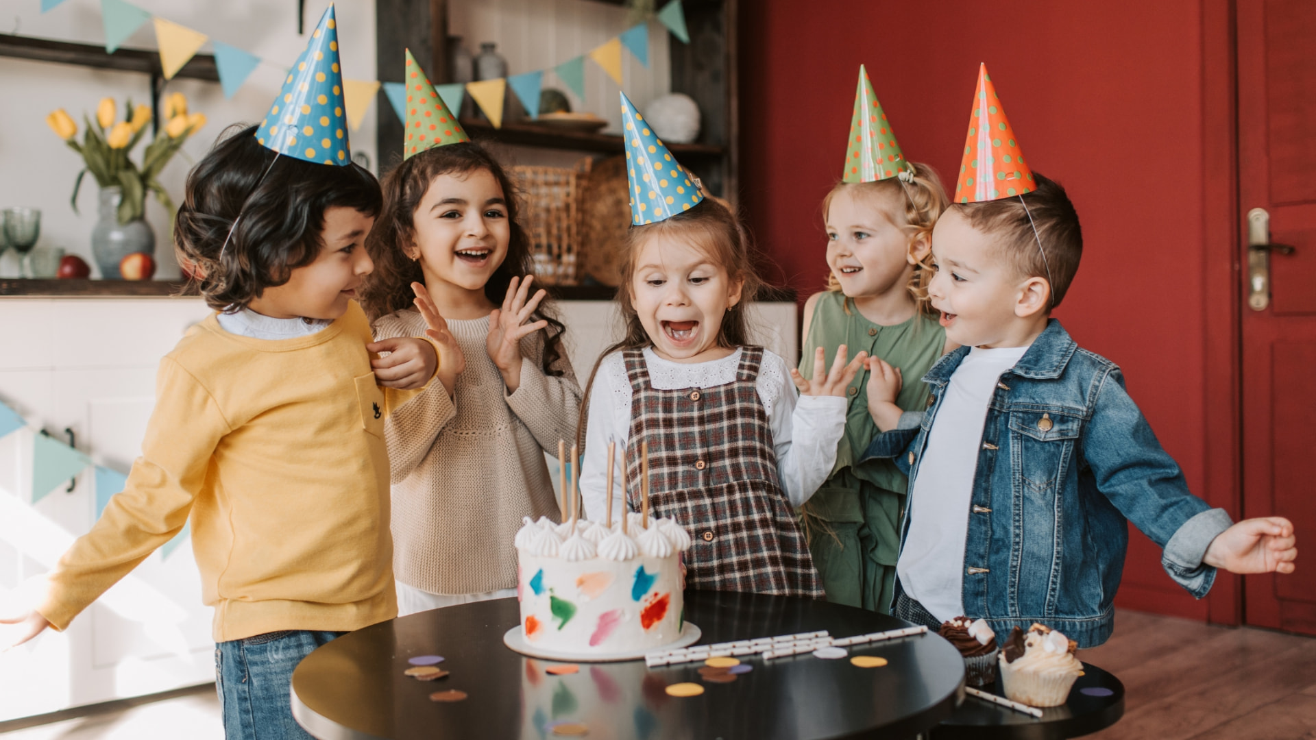 Children celebrating a birthday around a cake