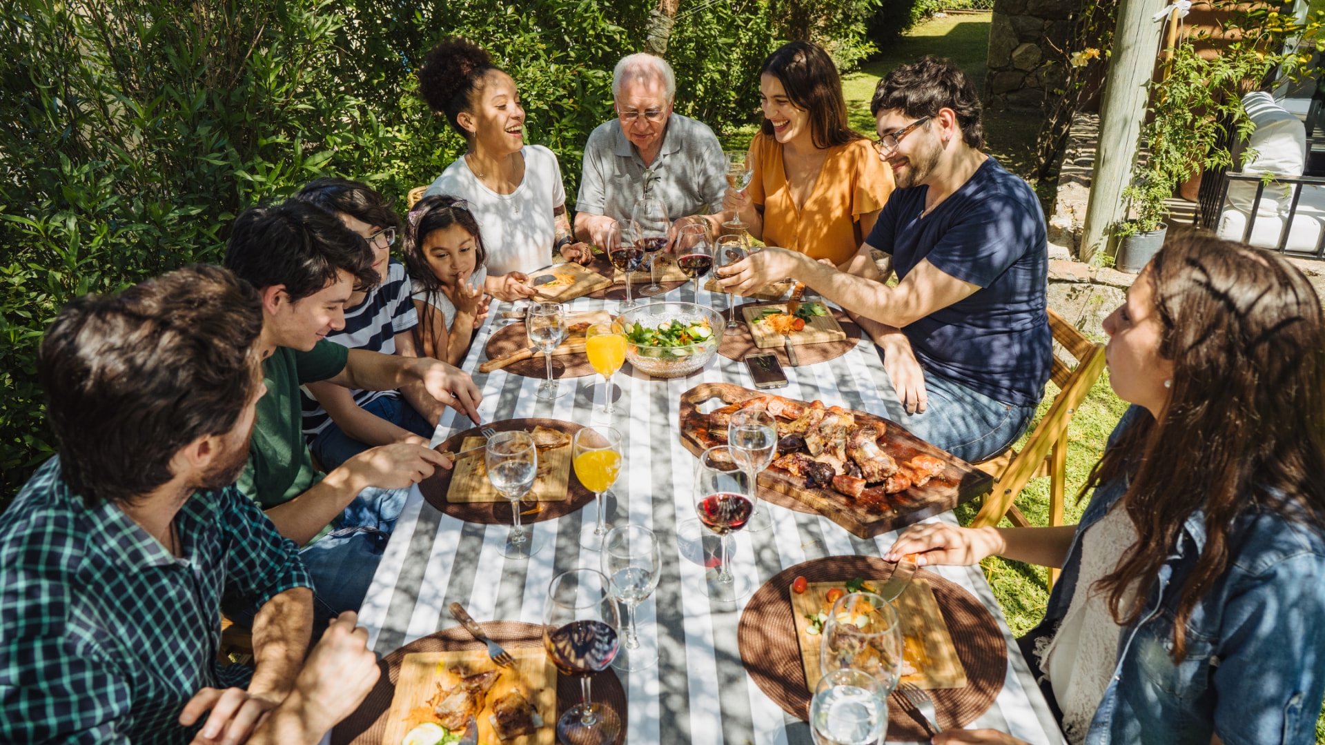 A family sharing an outdoor meal at a long table